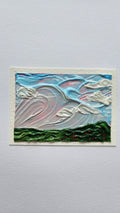 Mini painting of a large clouds and a field of flowers