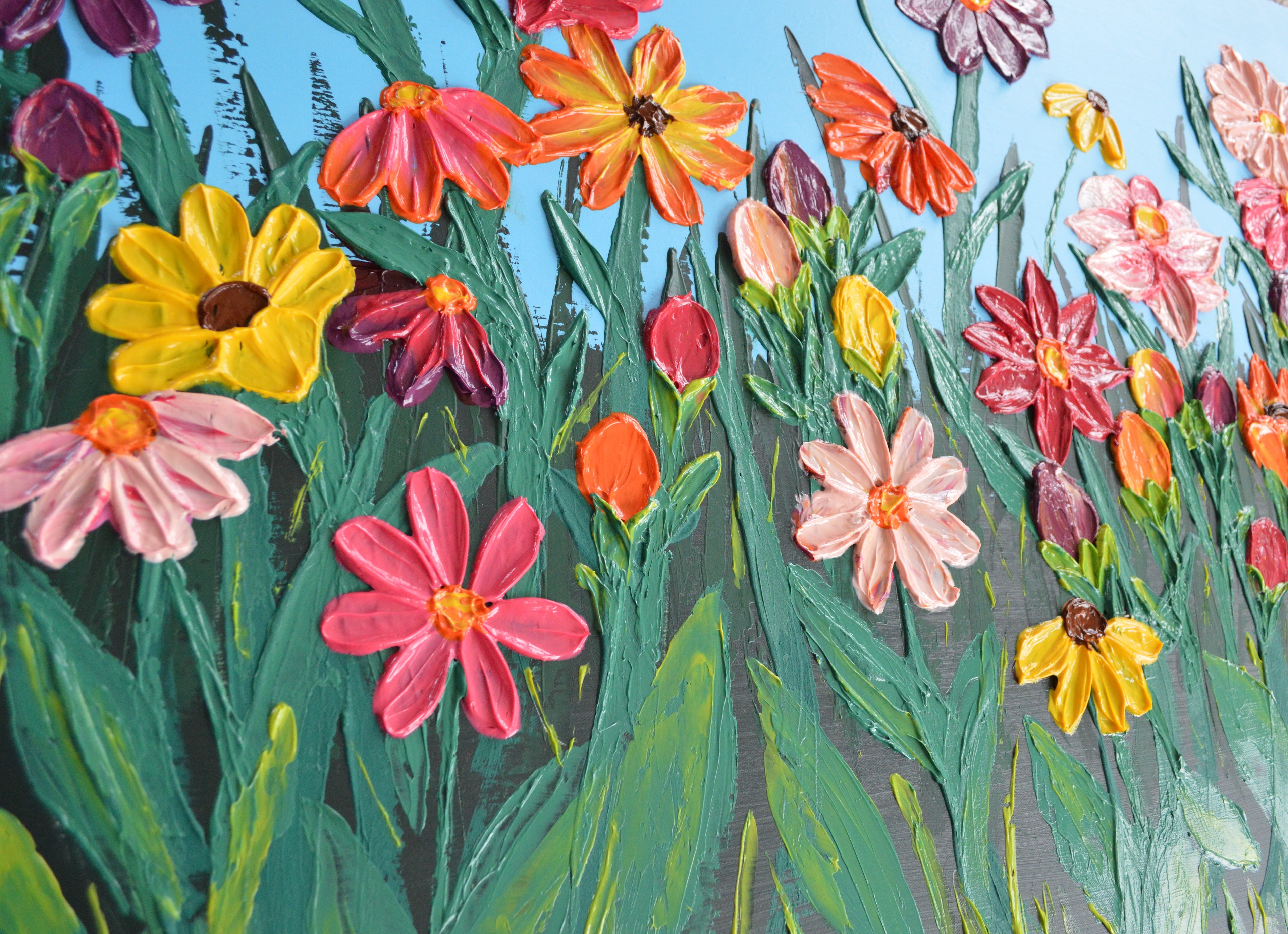 Colorful painting of a wildflower meadow and a blue sky